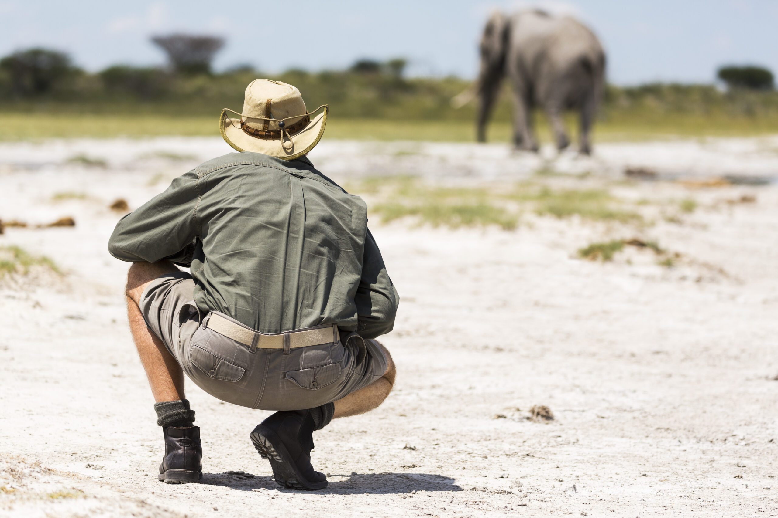 4-Day Mid-Range Wilderness Safari safari holiday,botswana,a guide crouching close to an elephant in nxai pan, botswana